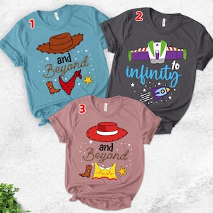 May include: Three graphic t-shirts. One is light blue with a cowboy hat, boots, and the words "and Beyond". Another is dark gray with a Buzz Lightyear design and the words "to infinity". The third is pink with a cowboy hat and the words "and Beyond".