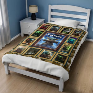 May include: A rectangular blanket featuring a collage of various green alien characters from the Star Wars universe, arranged in gold-toned frames. The central panel displays a large green alien with the name DANIEL printed in white text above it.