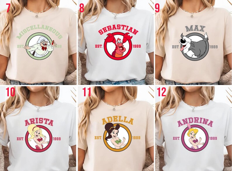 Puede incluir: Una colecci&oacute;n de camisetas con personajes de dibujos animados. Las camisetas son de varios colores, incluyendo blanco y beige. Cada camiseta tiene un gr&aacute;fico circular con la imagen y el nombre de un personaje, junto con el a&ntilde;o "1989".