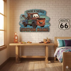 Puede incluir: Un letrero de madera con un cami&oacute;n de remolque de dibujos animados con el texto "TOWING & SALVAGE" y "CUSTOM NAME". El letrero est&aacute; montado en una pared de ladrillo blanco, con un letrero de la Ruta 66. Una bomba de gasolina roja y coches de juguete est&aacute;n sobre una mesa de madera.