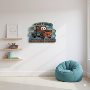 Puede incluir: Una pieza de arte mural de madera con un cami&oacute;n de remolque de dibujos animados con el texto "TOWING & SALVAGE" y "CUSTOM NAME". El cami&oacute;n es marr&oacute;n, azul y verde, sobre un fondo de vetas de madera azul y verde. El arte se exhibe en una pared blanca.
