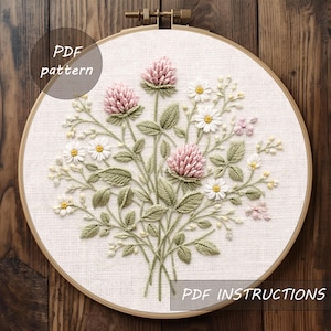 May include: Embroidered floral design with pink clover, white daisies, and green leaves, set in a wooden hoop. The text "PDF pattern" and "PDF instructions" are visible.