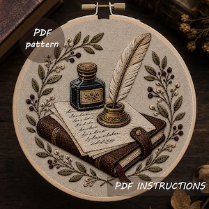 May include: An embroidery hoop containing a needlepoint design of a brown leather book, a square inkwell, and a quill pen resting on a piece of paper. The scene is framed by embroidered leafy branches with small berries. Text reads PDF pattern.