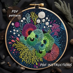 May include: An embroidered hoop with a colourful floral design. The artwork features green, purple, and pink flowers, with yellow and white accents, set against a dark blue background. The text "PDF pattern" and "PDF instructions" are visible. The hoop is held in a wooden frame.