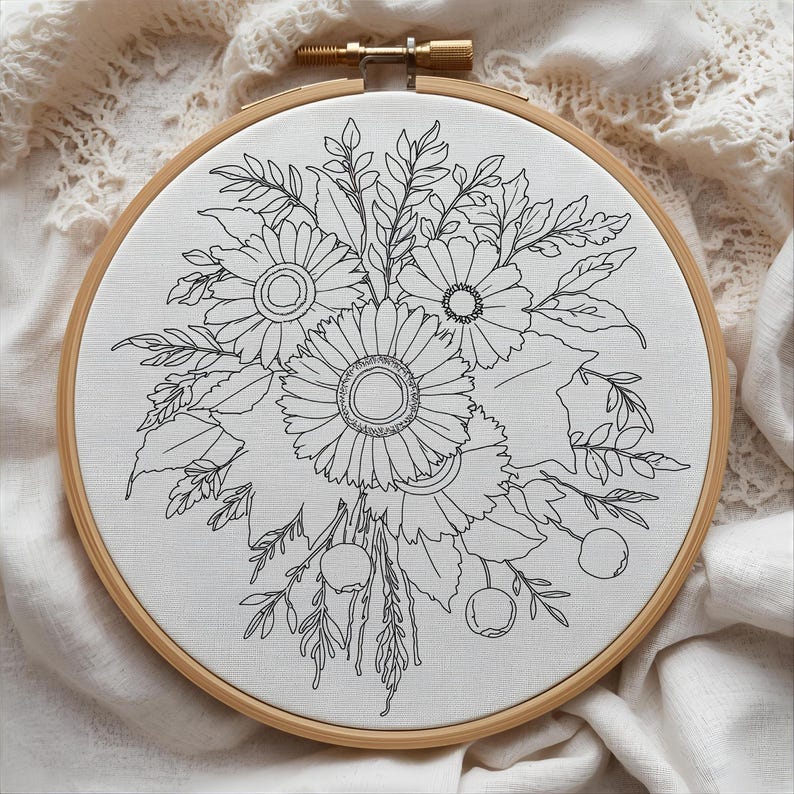 May include: A floral embroidery hoop featuring a detailed black and white design of sunflowers, leaves, and berries. The embroidery is set against a white fabric, framed by a natural wood hoop. The design is intricate and delicate.