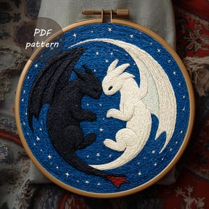 May include: Embroidered hoop art showing two dragons, one black and one white, facing each other on a blue starry background. The text "PDF pattern" is visible. The dragons are in a yin-yang style design.