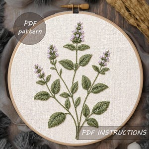 Könnte beinhalten: Gesticktes Blumendesign in einem Holzreifen. Das Kunstwerk zeigt grüne Blätter und lavendelfarbene Blüten. Der Text "PDF pattern" und "PDF instructions" ist sichtbar. Die Stickerei befindet sich auf einem cremefarbenen Stoff.