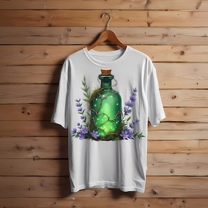 May include: White t-shirt featuring a green bottle design. The bottle is adorned with vines, a cork stopper, and surrounded by purple flowers and green foliage. The design has a fantasy or botanical theme.
