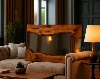 Puede incluir: Un espejo rectangular con un marco de madera natural de borde vivo y vetas pronunciadas. El espejo está colocado sobre un sofá capitoné de color beige y refleja el interior. El marco de madera muestra curvas orgánicas y un acabado marrón cálido.