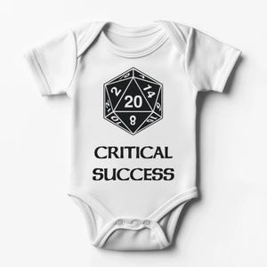Puede incluir: Body de bebé blanco con un gráfico negro de un dado de 20 caras y las palabras "CRITICAL SUCCESS" impresas debajo. El body tiene mangas cortas y corchetes en la parte inferior. Un regalo divertido para bebés.