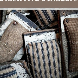 Peut inclure: Une collection d'aiguiers primitifs, également appelés coussins à épingles, fabriqués en tissu et en bois. Les aiguiers sont décorés de tissu rayé bleu et blanc et ont un aspect rustique et vintage.