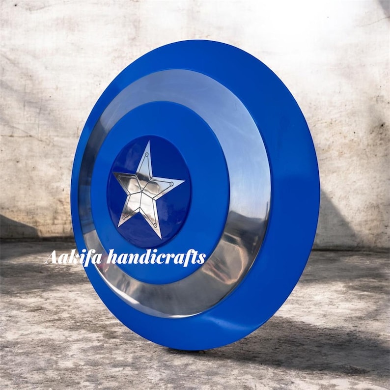 May include: A blue and silver shield with a central silver star design. The shield features concentric circles of blue and silver. The text "Aakifa handicrafts" is visible on the lower left side of the shield.