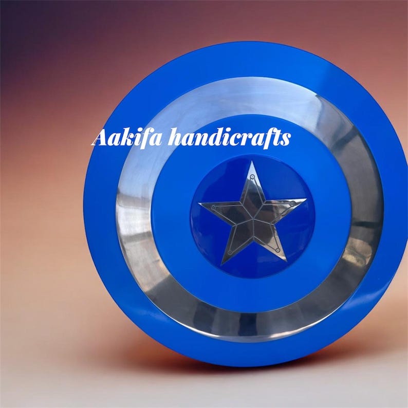 May include: A blue and silver shield with a central star design. The shield is circular with blue and silver concentric rings. The text "Aakifa handicrafts" is printed on the shield.
