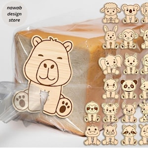 May include: A collection of light-coloured wooden bread clips featuring various animal designs, including a bear, sheep, koala, rabbit, monkey, elephant, panda, tiger, and sloth. The text "nawab design store" is visible in the upper left corner.
