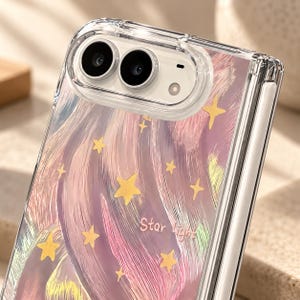 K&ouml;nnte beinhalten: Eine transparente Handyh&uuml;lle f&uuml;r ein faltbares Ger&auml;t mit einem gemalten Design aus wirbelnden rosa, violetten und gelben Pinselstrichen mit verstreuten gelben Sternen. Der Text "Star Light" ist in hellrosa Schreibschrift aufgedruckt.
