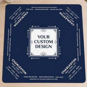May include: A square navy blue Mahjong mat featuring white text and graphics. The center displays a white square with the text YOUR CUSTOM DESIGN. The corners include Charleston rules, and the edges feature directional markers for play.