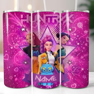 May include: A pink tumbler with a design featuring three animated characters, a star, and the word "HUNTRX". The tumbler has a purple banner with the word "NAME" on it. The background is filled with hearts and stars.
