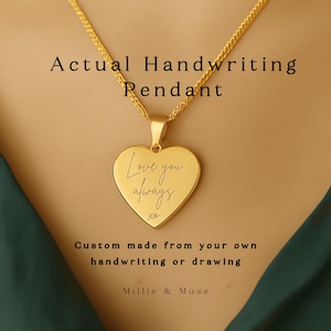 Pode incluir: Um colar com um pendente em forma de coração dourado. O pendente tem gravado as palavras "Love you always". O colar é feito sob medida a partir da sua própria caligrafia ou desenho. O texto "Actual Handwriting Pendant" está acima do pendente.
