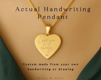 Puede incluir: Un collar con colgante en forma de corazón dorado. El colgante tiene grabadas las palabras "Love you always". El collar está hecho a medida a partir de tu propia escritura o dibujo. El texto "Actual Handwriting Pendant" está encima del colgante.