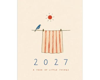 May include: A 2027 wall calendar with a cream-colored background featuring a blue bird perched on a clothesline next to a striped towel hanging from two clips under a red sun. The text 2027 and A YEAR OF LITTLE THINGS are printed below.
