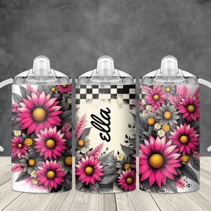 May include: Three baby sippy cups with floral designs. The cups feature bright pink and yellow flowers with gray and white accents. One cup has the name "Ella" in black script. Each cup has a white handle and a clear lid.
