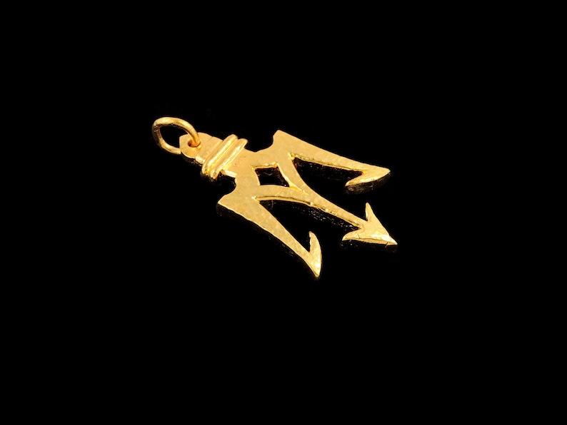 May include: A gold-colored trident pendant charm. The trident is a three-pronged spear, a symbol of power and strength.
