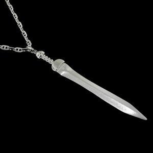 May include: A silver chain necklace with a silver sword pendant. The sword is detailed with a textured surface and a pointed tip.