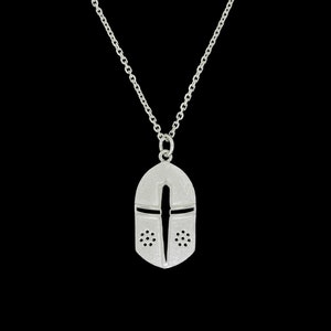 May include: A silver necklace with a pendant shaped like a knight's helmet. The helmet has a cross design and small holes around the face.