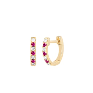 Peut inclure: Une paire de boucles d'oreilles créoles dorées. Chaque boucle d'oreille présente une rangée de pierres précieuses rouges et blanches alternées. Les pierres précieuses sont serties en ligne sur le devant de la créole. Les boucles d'oreilles ont un design simple et élégant.