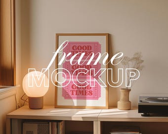 May include: A wooden framed pink poster with the words "GOOD TIMES" in white, displayed on a wooden shelf. A spherical lamp and a small vase with dried flowers are also on the shelf. The text "frame MOCKUP" is overlaid on the image.