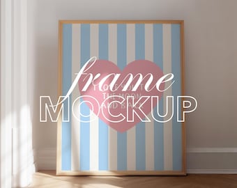 Op de afbeelding: Een ingelijste kunstafdruk mockup met een roze hart en de tekst "I love you to the moon and back" op een blauw en wit gestreepte achtergrond. De lijst is van licht hout en de tekst "frame MOCKUP" is overgelegd.