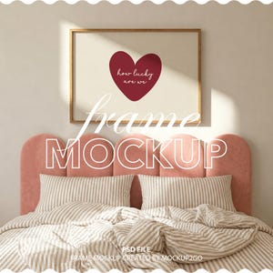 May include: A framed mockup featuring a burgundy heart with the text "how lucky are we" on a cream background. The frame is gold-toned, and the mockup is set above a bed with striped bedding and a pink headboard. The word "frame" and "mockup" are also visible.