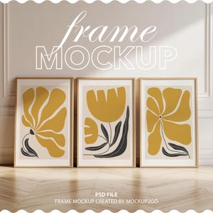 Puede incluir: Tres impresiones artísticas enmarcadas con diseños florales abstractos en amarillo mostaza, negro y beige. Los marcos son de color madera clara. El texto "frame MOCKUP" está en la parte superior y "PSD FILE FRAME MOCKUP CREATED BY MOCKUP2GO" en la inferior.