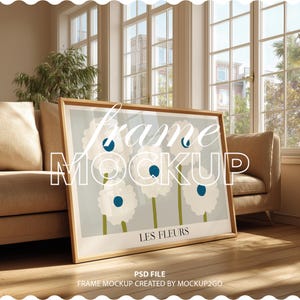 Puede incluir: Un cuadro con una impresión artística de flores blancas con centros azules y tallos verdes sobre un fondo gris claro. El texto "LES FLEURS" está debajo del diseño floral. El marco es de color madera clara. La palabra "frame MOCKUP" está superpuesta.
