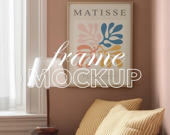May include: A framed art print with the word "MATISSE" at the top. The print features colourful abstract shapes in pink, blue, orange, and yellow. The frame is displayed above two striped pillows and a lamp.