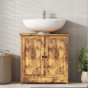 May include: A rustic wooden bathroom vanity with a distressed finish. The vanity features two cabinet doors with black knobs and a white, round vessel sink. A chrome faucet is mounted on the sink. The vanity is set against a tiled wall.