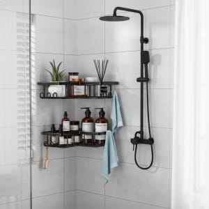 May include: A modern black shower system with a rain shower head and handheld sprayer. Two black metal corner shelves hold toiletries, plants, and accessories. Light blue towels hang on the shelves, and a small brush hangs on the lower shelf.