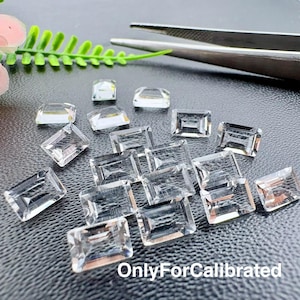 Pode incluir: Uma coleção de pedras preciosas transparentes de corte retangular dispostas sobre uma superfície escura, acompanhadas por uma pinça metálica. O texto "OnlyForCalibrated" está impresso em branco no canto inferior direito.
