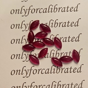 May include: A collection of oval-shaped, deep red gemstones scattered on a white surface. The gemstones have a polished, glossy appearance. The words "onlyforcalibrated" are printed repeatedly in a light gray font across the background.