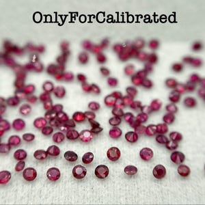 May include: A collection of small, round, faceted red gemstones scattered across a white surface. The text "OnlyForCalibrated" is printed in black at the top center. Each gemstone displays a deep crimson hue with multiple reflective facets.