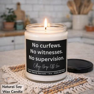 May include: A lit soy wax candle in a glass jar with a black label. The label reads "No curfews. No witnesses. No supervision." and "College Drop-Off Era." The candle is 9 oz and is vegan, natural, and non-toxic.