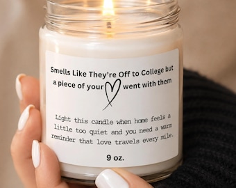 May include: A clear glass jar candle with a white wax fill and a lit wick. The label features black text reading: Smells Like They're Off to College but a piece of your heart went with them. Light this candle when home feels a little too quiet and you need a warm reminder that love travels every mile. 9 oz.