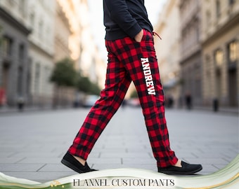 May include: Red and black plaid flannel pants with the name "ANDREW" printed vertically in white on the left leg. The pants have a drawstring and pockets. The text "FLANNEL CUSTOM PANTS" is at the bottom of the image.