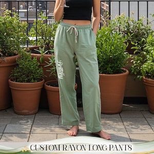 May include: Light green rayon long pants with a drawstring waist and the name "Brittany" printed vertically on the left leg. The pants are part of a casual outfit. The text "CUSTOM RAYON LONG PANTS" is at the bottom of the image.