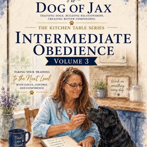 以下が含まれることがあります： Anne Baxter, CDT著「Dog of Jax Intermediate Obedience Volume 3」のブックカバー。青いシャツを着た人物がキッチンテーブルで黒い犬を訓練している様子が描かれており、「Training Dogs, Building Relationships, Creating Better Companions」や「Taking Your Training to the Next Level」といったテキストが含まれています。