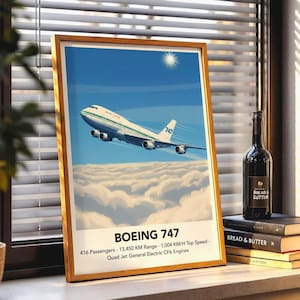 以下が含まれることがあります： 晴れた空の下、雲の上を飛ぶボーイング747旅客機の額入りプリント。プリントには「BOEING 747」の文字と仕様が記載されています。ワインボトルと本が隣にあります。