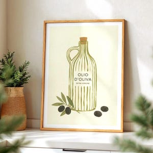 May include: A framed print with an olive oil bottle illustration, the text reads "OLIO D'OLIVA EXTRA VERGINE". The artwork shows olive branches and olives. The print is set against a light background.