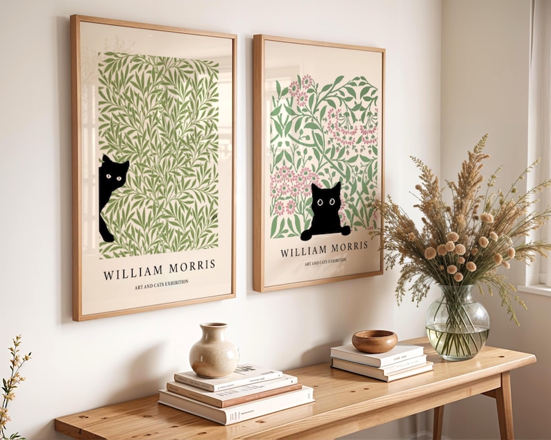 May include: Two framed art prints featuring William Morris designs with black cat silhouettes. One print has green foliage, the other pink flowers. The text "WILLIAM MORRIS ART AND CATS EXHIBITION" is below the images.