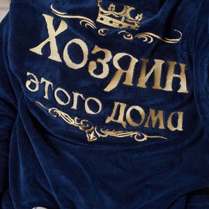 May include: Navy blue hooded robe with gold embroidered text and crown design. The text reads "Хозяин этого дома" in gold lettering. The robe is made of a soft, plush material.
