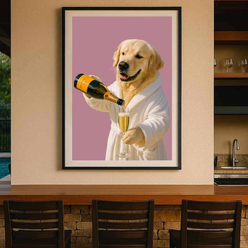May include: Framed print featuring a Golden Retriever in a white robe pouring champagne into a glass. The dog is smiling, and the background is a solid mauve color. The champagne bottle has a black and gold label.